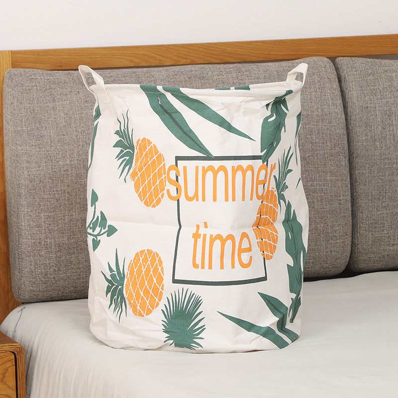 Panier à linge ananas et feuilles vertes, décoration naturelle.